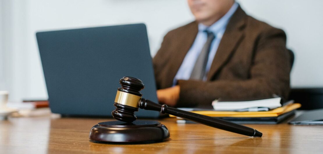 crop asian judge working on laptop in office